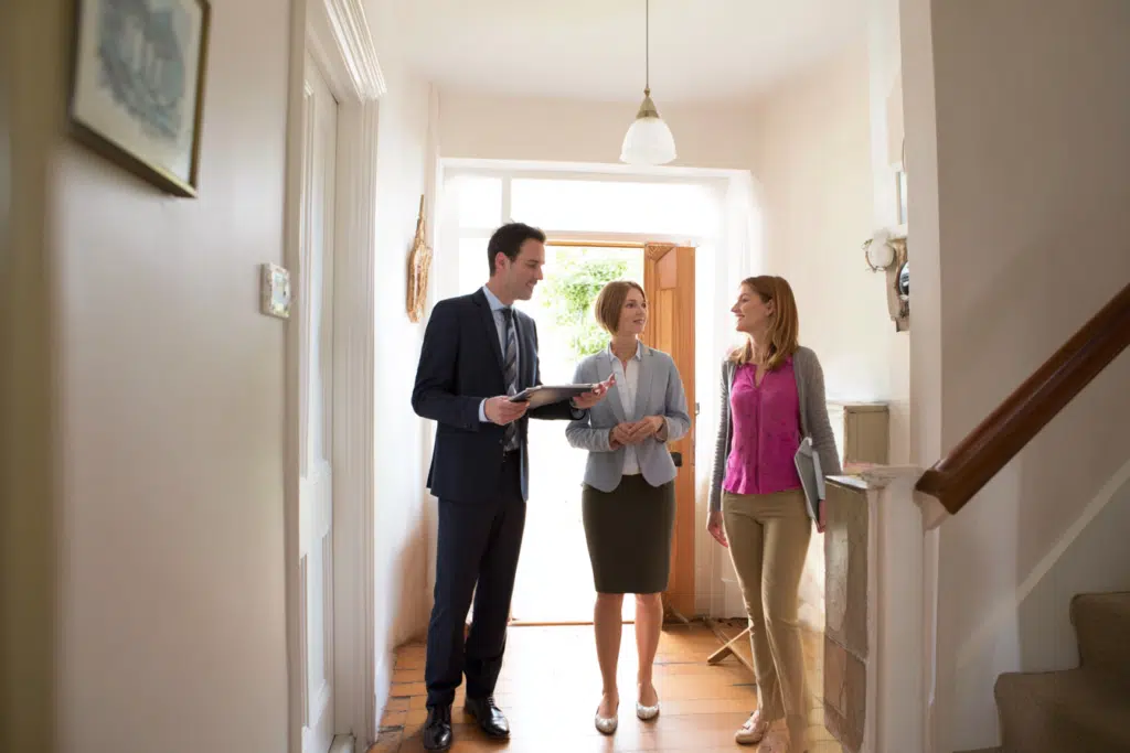 An auction representative showing prospective buyers around a property