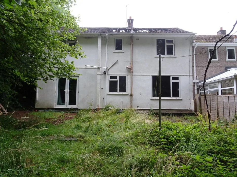 Rear view of the fire damaged Plymouth house showing roof and structural damage