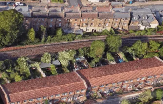 A satellite view of a row of houses with gardens backing directly onto railway tracks