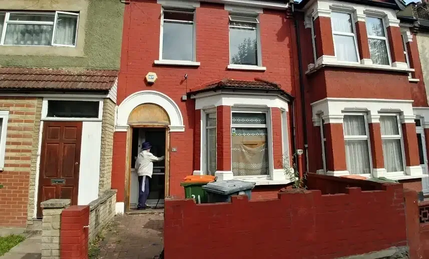 A man entering a derelict terraced house to view it ahead of an auction sale
