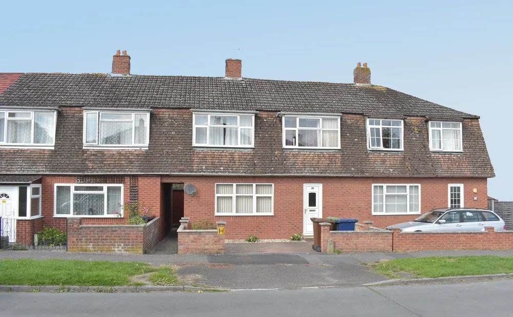 A row of non-standard PRC concrete houses on a UK residential street