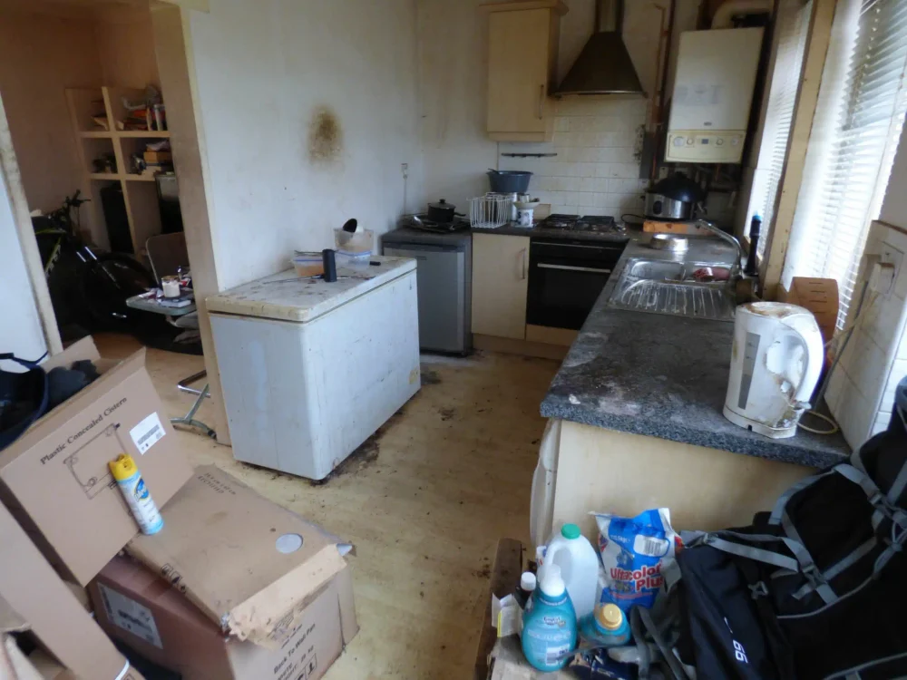 A cluttered, neglected kitchen in a house being sold in poor condition