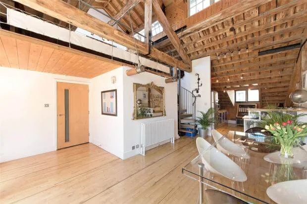 Interior of the converted warehouse loft flat in Shad Thames, London SE1, sold by auction - exposed wooden beams, rafters and open-plan living space